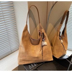 Detail view of brown tote bag with abstract texture and decorative coffee cup charm