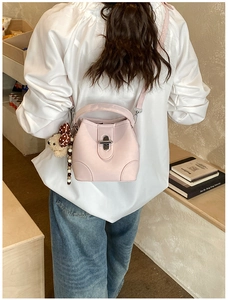 Detail of light pink bucket bag with silver twist lock and cute teddy bear keychain charm