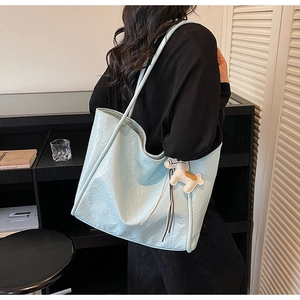 Detailed view of light blue large capacity tote bag with horse charm on black strap