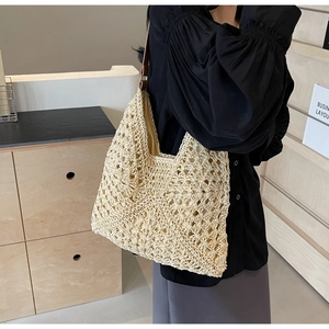 Detailed view of hand-woven crochet beach tote with brown leather strap and fabric lining