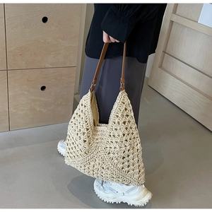 Detailed macro view of hollow floral crochet pattern on a beige woven tote beach bag