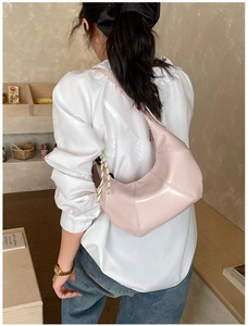 Pink crescent shoulder bag side view showing high-quality leather texture and strap detail