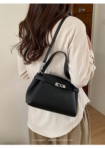 Rear view of a model wearing a black litchi pattern leather bag in a retro vibe style