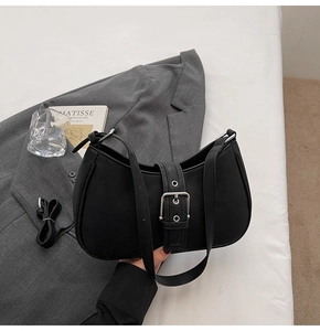 Detail of black half-moon shoulder bag with silver buckle and detachable strap