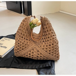 Detail view of woven hobo beach bag with intricate cut-out patterns and leather strap