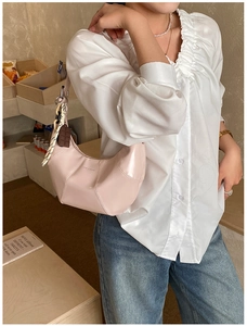 Pink glossy hobo bag with chocolate charm and woven rope detail shown on shoulder