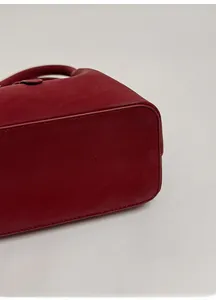 Close-up of reinforced base and stitching on a vintage wine red leather bucket bag