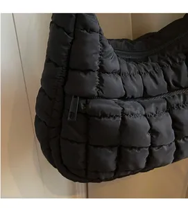 Detailed view of black quilted puffer bag featuring soft fabric and metal zipper closure