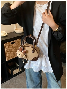Close-up of stylish retro color-block pillow bag with brown plush bear charm and gold studs