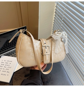 Detail of beige PU leather shoulder bag with silver buckle and lace pearl charm