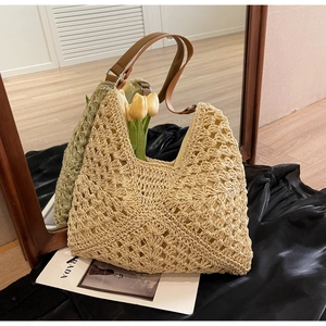 Detailed view of hollow woven texture and brown leather strap on beach tote bag