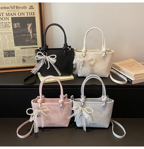 Détail de quatre sacs seaux chic avec nœuds en dentelle et perles sur fond vintage