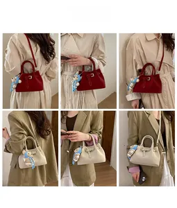 Detail shots of minimalist bucket bag in deep red and beige with a cute bear charm accessory