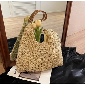 Detail of hollow woven beach tote bag with brown leather straps and tulip decor