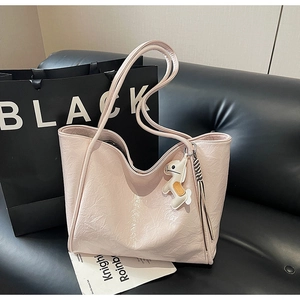 Close-up of pink leather tote bag with subtle texture and stylish horse charm