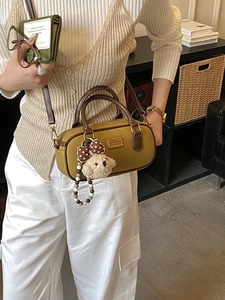 Yellow barrel handbag with brown leather straps and a cute plush dog charm