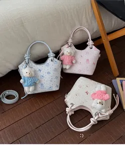 Detail of macaron-colored embossed bucket bags with heart patterns and cute teddy bear charms