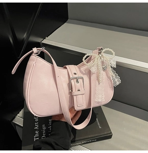 Detail of pink PU leather bag with pearl bow, lace ribbons and silver buckle hardware