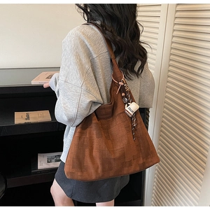 Close-up of brown canvas tote bag with geometric pattern and coffee cup charm