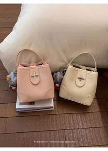 Detail of lychee pattern leather bucket bags with bear pendants and silver locks