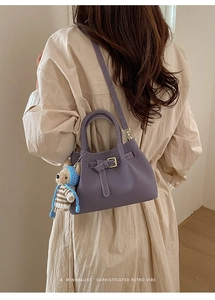 Detailed back view of a purple retro crossbody bucket bag worn with a beige trench coat
