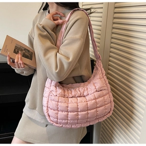 Close-up of pink quilted puffer shoulder bag showing soft texture and square stitching