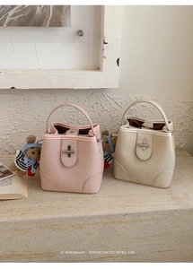 Close-up of pink and beige bucket bags showing lychee texture leather and metal locks