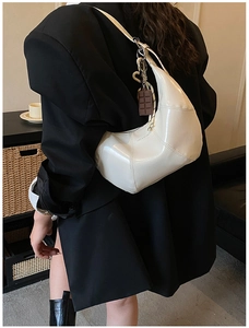 Chic beige hobo bag with glossy finish and chocolate-shaped charm detail