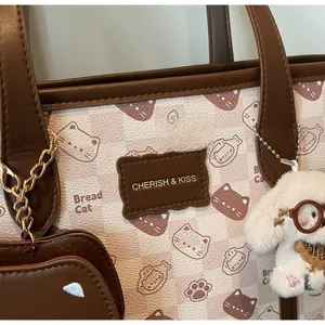 Dettaglio della borsa shopper a scacchi con stampe di gatti e ciondolo in peluche