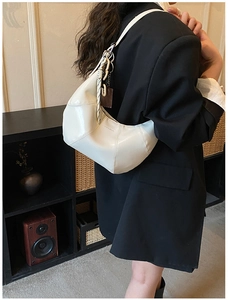 Detail of white half-moon bag with cross stitching and braided knot strap detail