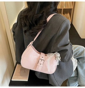 Detailed view of pink leather hobo bag with pearl lace pendant and silver buckle strap