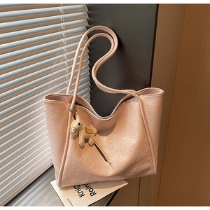 Close-up of pale pink tote bag with crinkled texture and cute horse charm detail