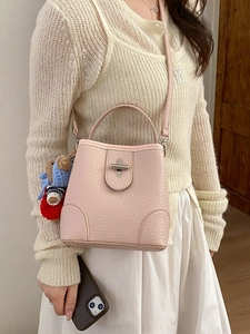 Pink pebbled leather bucket bag with silver twist lock and cute teddy bear charm