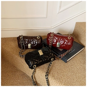 Three quilted chain bags in coffee, red and black leather on stairs with gold hardware