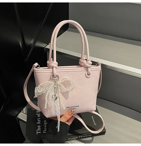 Gros plan du sac seau rose avec un nœud en dentelle de perles et une texture en cuir PU fin