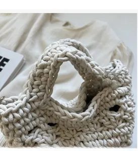 Close-up of durable woven handle on cream crochet beach bag with detailed texture