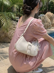 White leather shoulder bag with buckle detail and pearl charm for summer fashion style