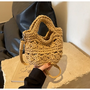 Detail of khaki crochet mini bag with hollow woven texture and sturdy braided shoulder strap