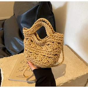 Close-up of khaki woven crossbody bag with detailed knit texture and slim strap