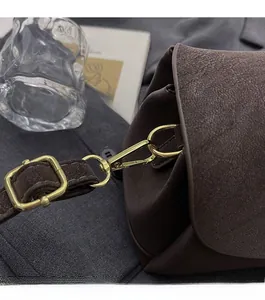 Détail du sac en cuir mat marron foncé avec boucles métalliques dorées haut de gamme