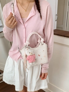 Chic off-white pleated bucket bag with pink bow accents and cute bear keychain charm