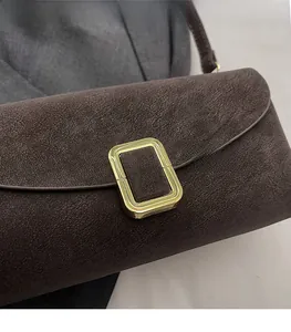 Détail du sac vintage marron mat avec une boucle métallique rectangulaire dorée élégante