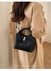 Detailed view of the black lychee pattern leather bucket bag with silver lock and strap