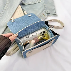 Internal layout of denim and leather crossbody bag showing spacious storage compartments