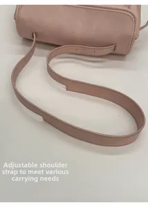Détail de la bandoulière réglable en cuir rose avec coutures raffinées et finitions