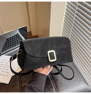 Détail du sac à bandoulière noir mat avec boucle en métal doré et design vintage
