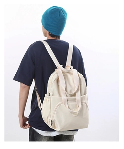 Detailed view of the large capacity beige backpack showing the waterproof nylon fabric and zipper