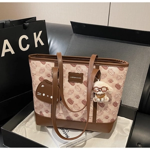 Dettaglio della borsa tote con motivi di gatti e accessori in una confezione regalo