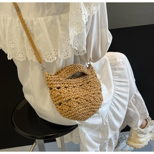 Detail of hand-woven straw bag texture with a circular handle and woven shoulder strap