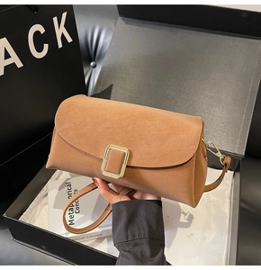 Détail du sac à main en daim camel avec boucle métallique et bandoulière réglable